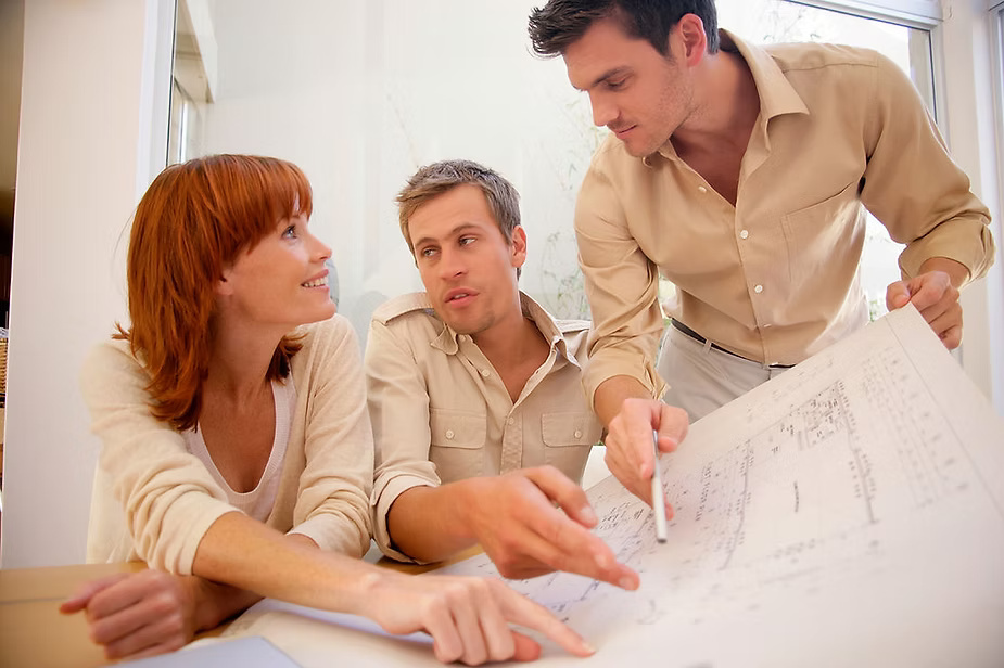 Group of professionals collaborating over blueprints.