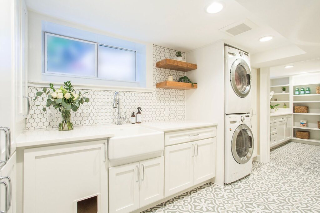 Modern white laundry room with front-load washer and dryer, and wood accents.