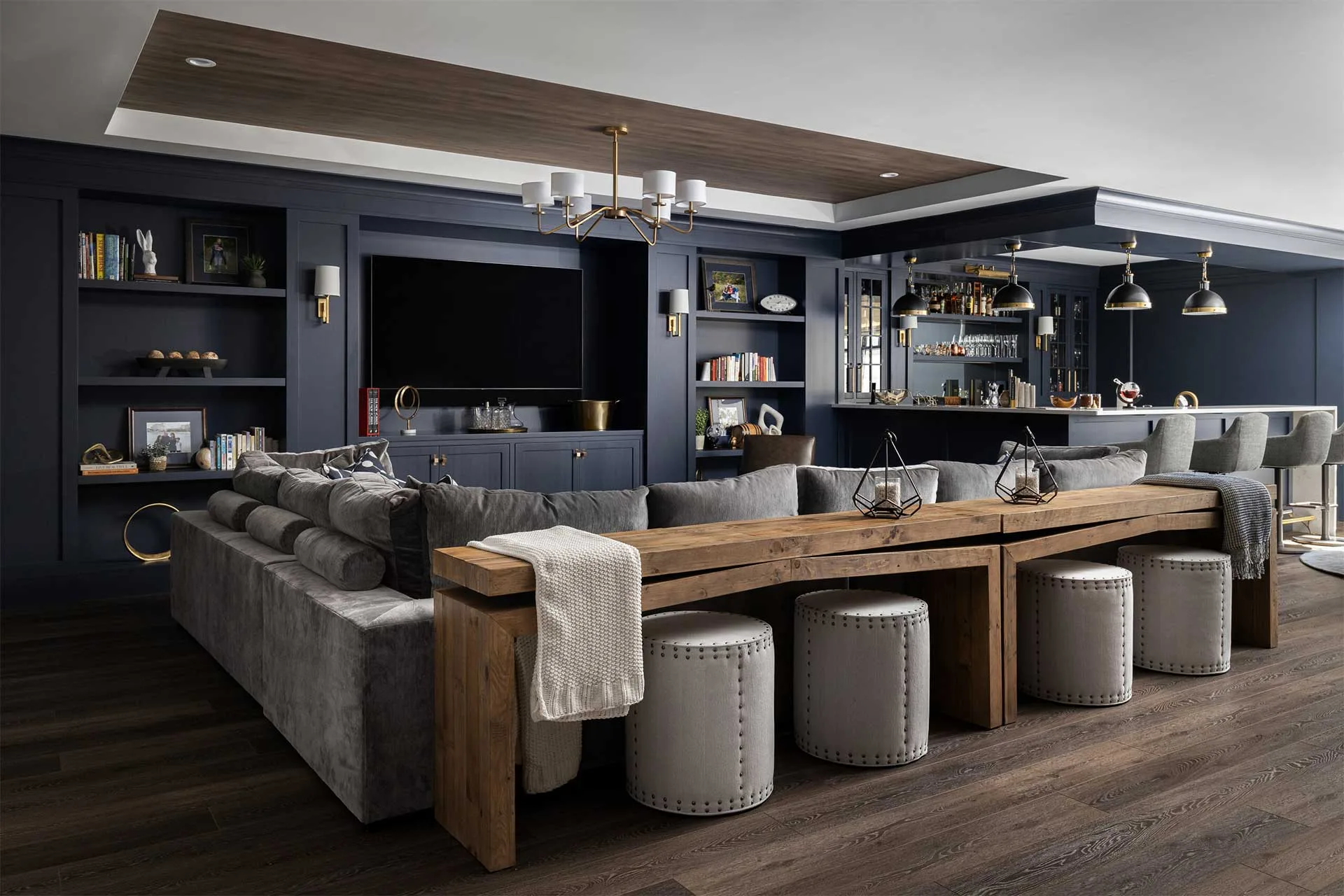 Contemporary living room with dark tones and ottoman seating.
