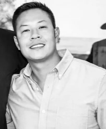 Friendly young man in a casual button-down shirt, smiling at camera.