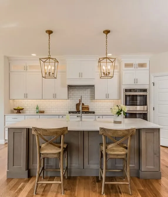 Stylish kitchen with wooden island, white cabinetry, and woven pendant lights.