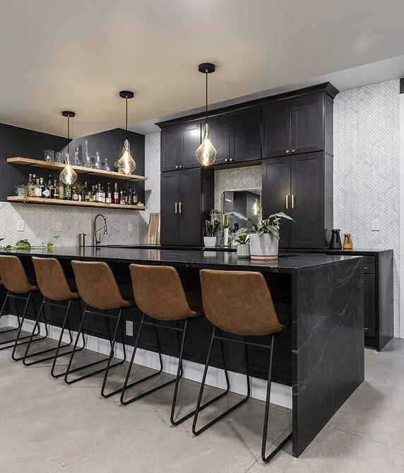 Contemporary home bar and kitchen area featuring a sleek black island with waterfall countertops and six brown leather bar stools with metal legs.