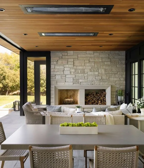 Patio with dining table, stone fireplace, and outdoor ceiling heater.
