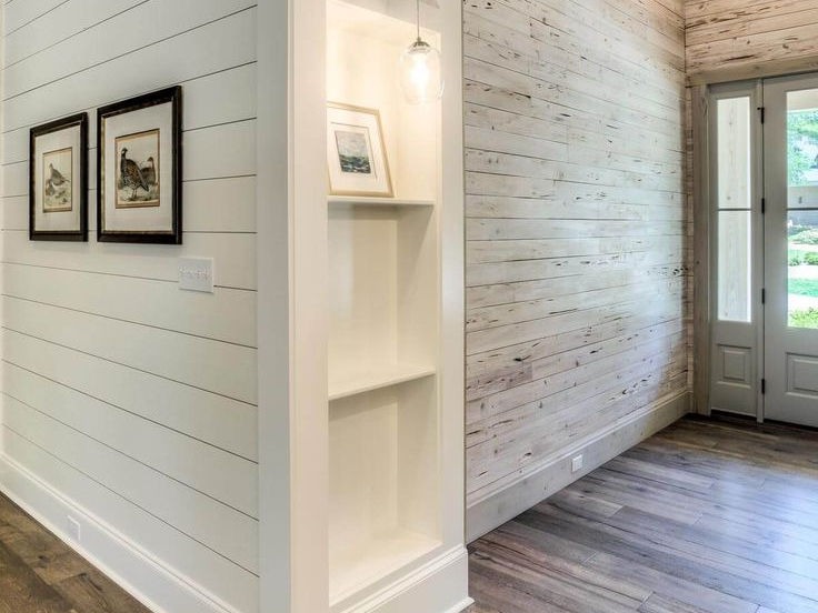 Narrow hallway with white shiplap walls and small recessed shelving.