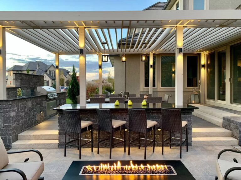 Luxurious outdoor lounge with white and peach cushions beside natural elements.
