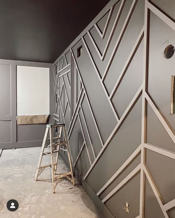 Gray wall with decorative wood trim in geometric patterns.