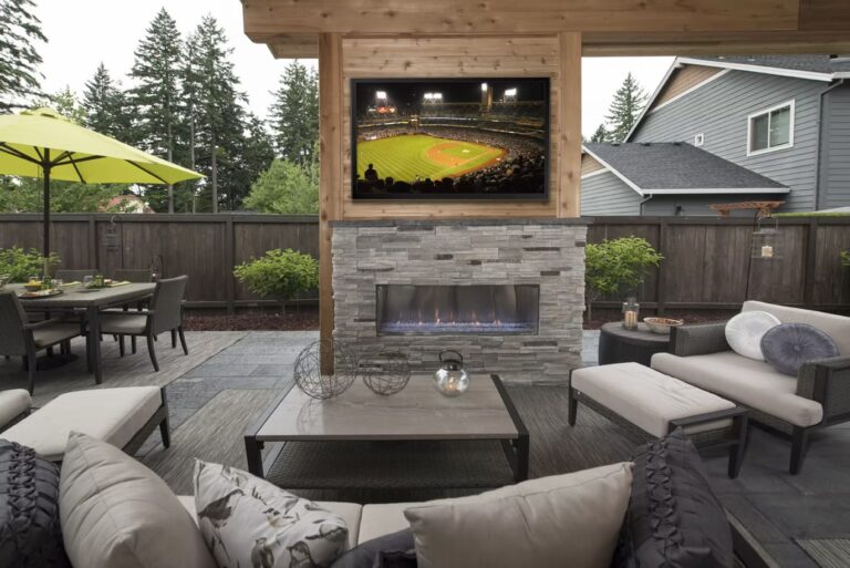 Covered patio space with built-in TV and stone fireplace.