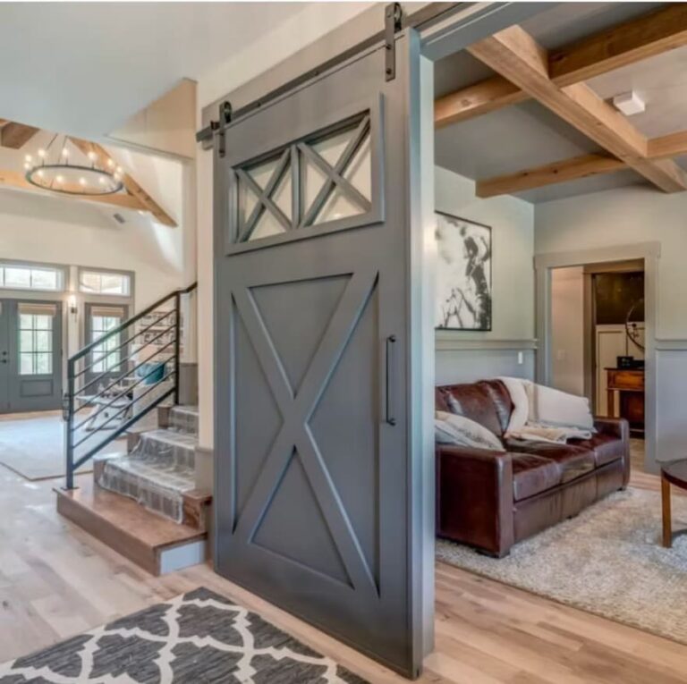 Interior of a house with rustic double barn doors leading to a cozy room.