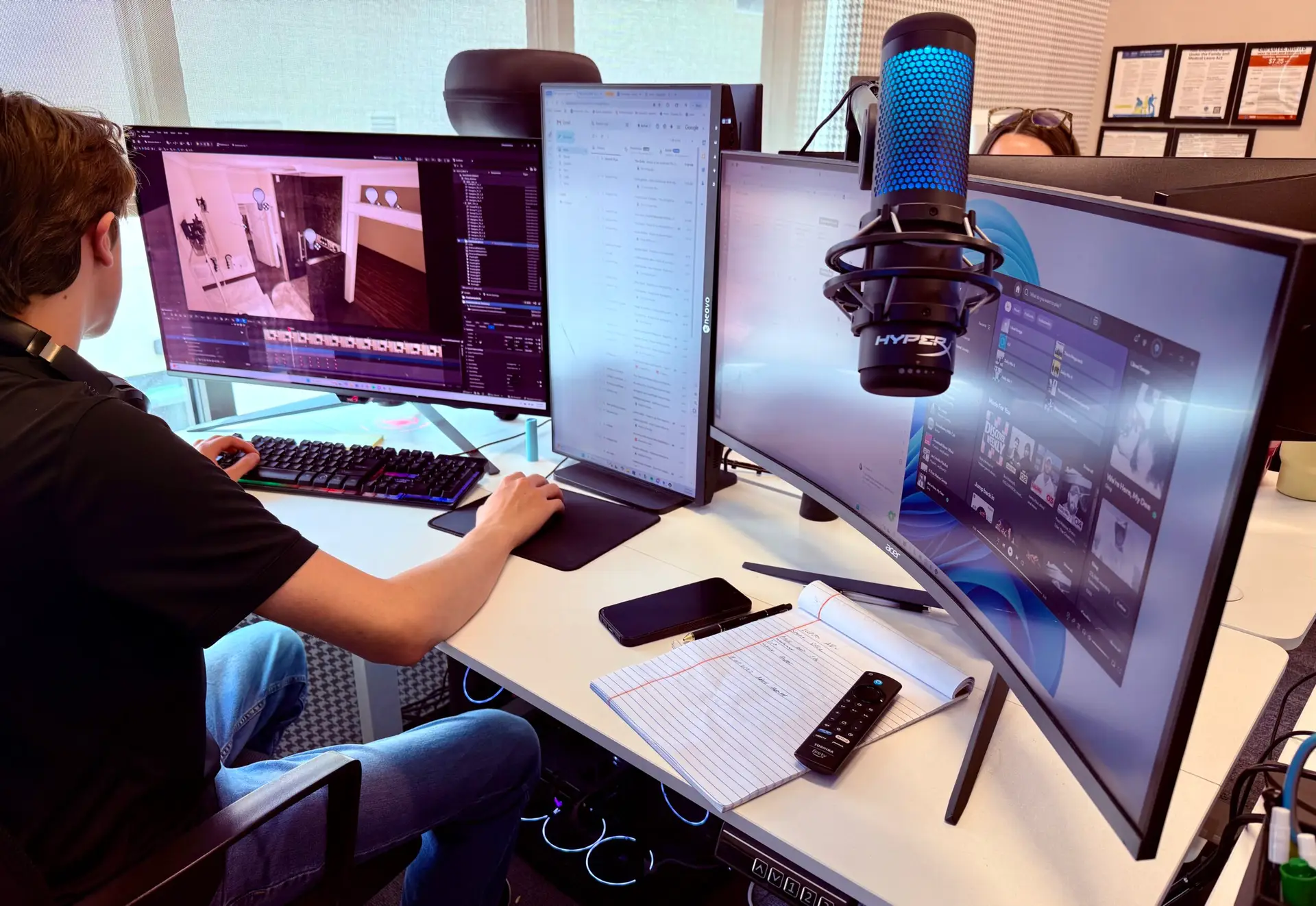 High-tech workspace with dual curved monitors, a microphone, and notes on a white desk.