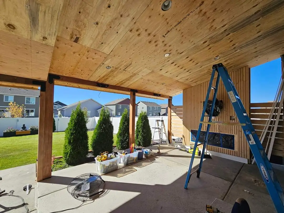 Partially built wooden patio with exposed beams and a ladder.