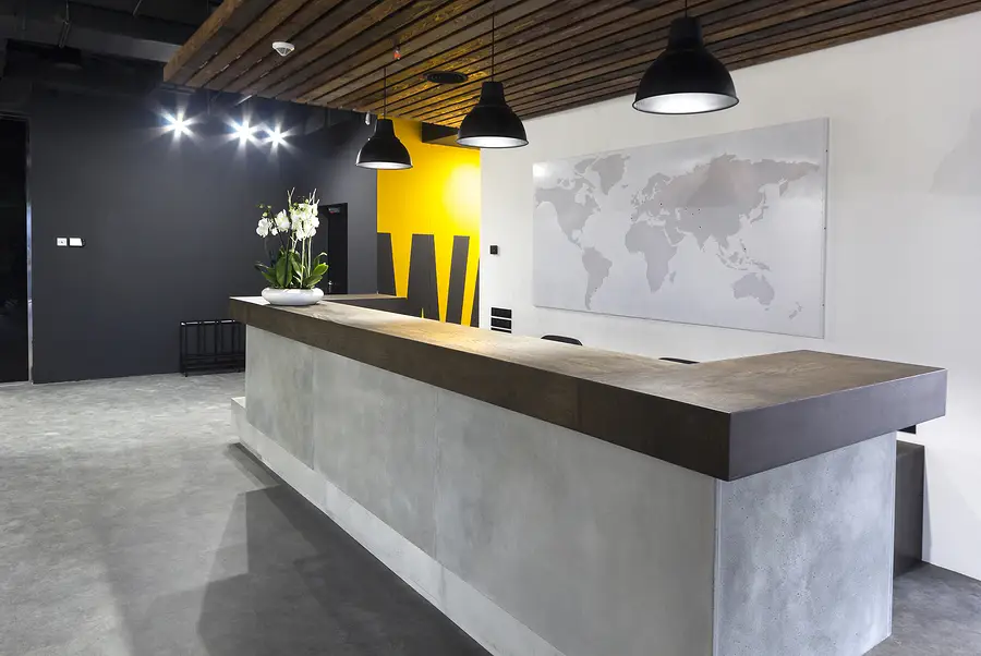 Contemporary reception desk in an office with minimalist and industrial decor.