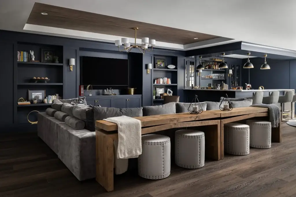 Large Sectional & Console: A wide view of a modern living room with a gray sectional sofa and a long wooden console table with matching stools.