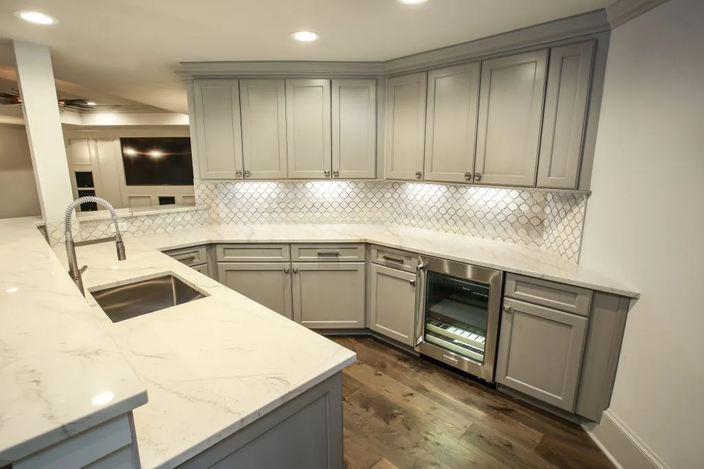 Contemporary Kitchen Corner: A close-up of light gray kitchen cabinetry with white marble countertops and under-cabinet lighting.