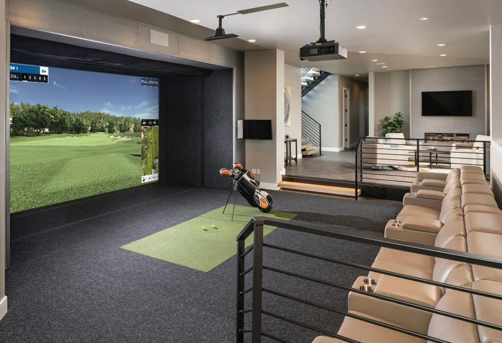 Indoor Golf Simulator: A high-end home sports room featuring a professional golf simulator and green turf hitting mat.