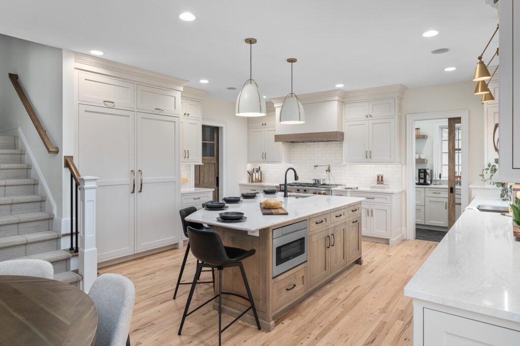 Open Concept Kitchen: A bright, airy kitchen with light wood floors, a large central island, and modern stainless steel appliances.