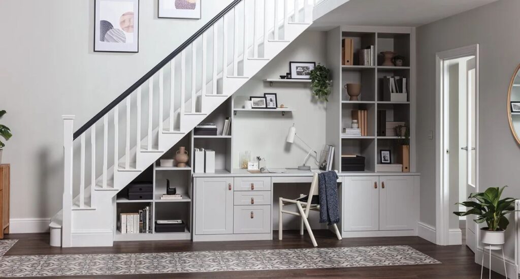Under-Stair Workspace: A clever use of space featuring a built-in white desk and shelving unit tucked neatly under a staircase.