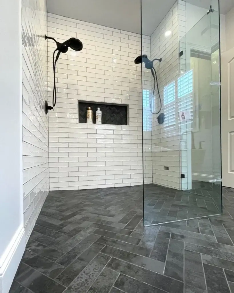 Dark tiled walk-in shower with glass enclosure and rainfall showerhead