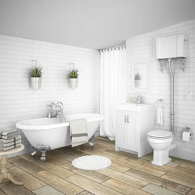 White bathroom with clawfoot tub and toilet on wood-look flooring
